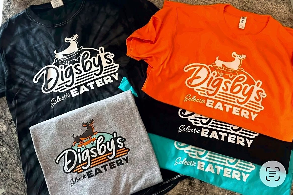 Custom printed Digsby's Eatery t-shirts in white, orange, black and teal laid out together