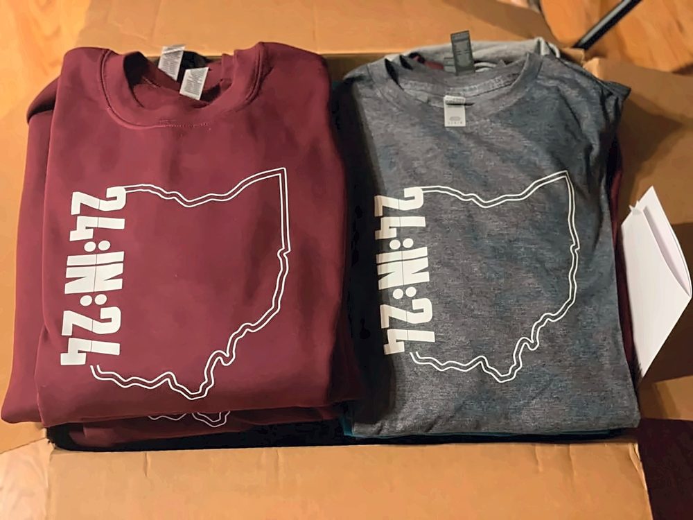 Maroon and grey Ohio-design crewnecks folded in a shipping box ready to go out